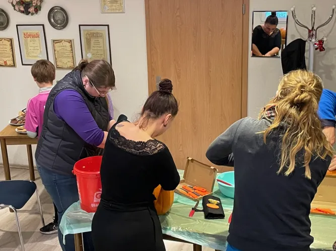 Gartenfreunde beim Kürbisschnitzen