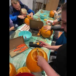 Gartenfreunde beim Kürbisschnitzen